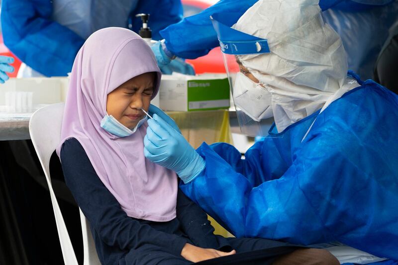 A doctor collects a sample for a coronavirus test from a child in Shah Alam on the outskirts of Kuala Lumpur, Malaysia. The recovery movement control order (RMCO) throughout the country has been extended until March 31, 2021, said Senior Minister (Security Cluster) Datuk Seri Ismail Sabri Yaakob. AP Photo