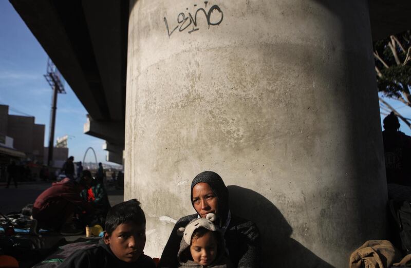 Honduran mother Lorena sits on the street with two of her four children, Yasir (L) and Maria, who all trave'led together for more than one month in the 'migrant caravan', in Tijuana, Mexico. Getty