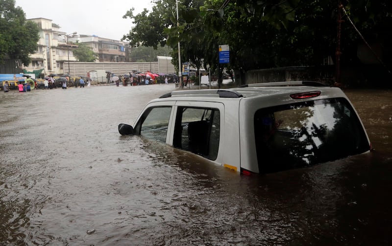 A car is seen seen submerged in a flooded street following heavy rains in Mumbai. Rajanish Kakade / AP Photo