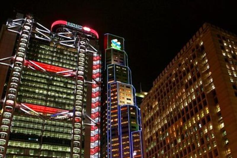 The HSBC Main Building, left, The Standard Chartered Bank Building, center and Princes Building, right, are illuminated at night in Hong Kong, China, on Monday, Jan. 24, 2011. Hongkong Electric Holdings Ltd., the utility controlled by billionaire Li Ka-shing, will hold an E.G.M. on Wednesday, Jan. 26. Photographer: Dale de la Rey/Bloomberg *** Local Caption ***  793709.jpg