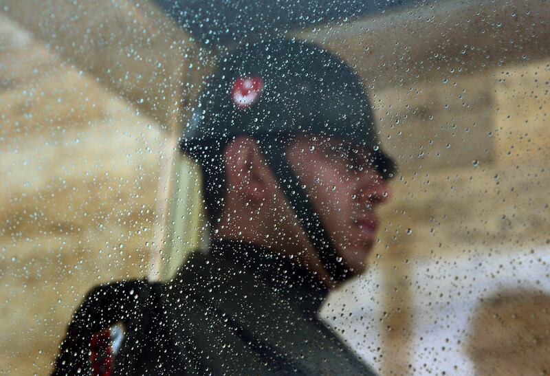 A Turkish soldier is seen behind the glass of his cubicle covered in rain droplets as he guards the mausoleum of modern Turkey's founder Mustafa Kemal Ataturk in Ankara, Turkey. AP Photo