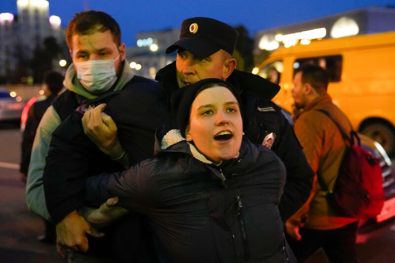 Riot police detain a demonstrator in Moscow, Russia. AP