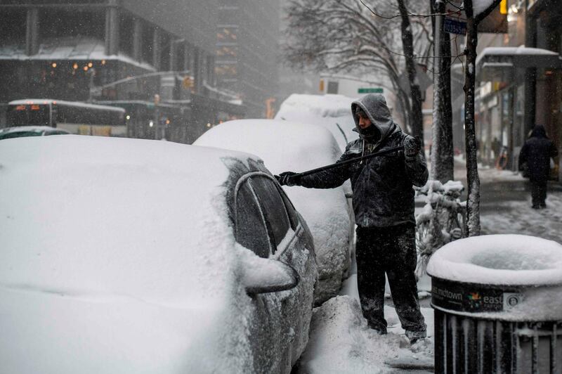 A man cleans snow from his car  in New York. Jewel Samad /AFP Photo