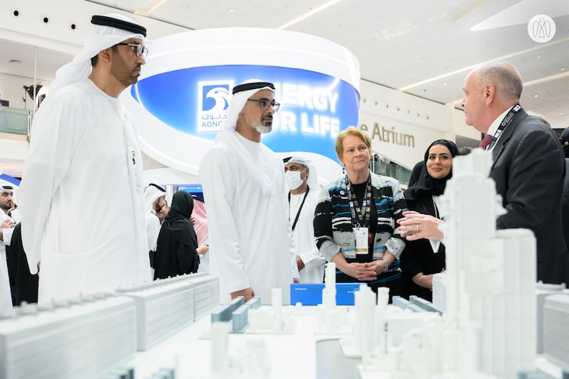 Sheikh Khaled bin Mohamed, member of the Abu Dhabi Executive Council and chairman of the Abu Dhabi Executive Office, is given a briefing at one of the exhibition stands at Adipec, during a tour with Dr Al Jaber. Photo: Abu Dhabi Media Office