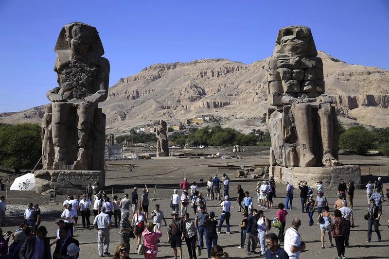 Tourists behold the Colossi of Memnon, two massive stone statues of Pharaoh Amenhotep III at Luxor. Hassan Ammar / AP Photo
