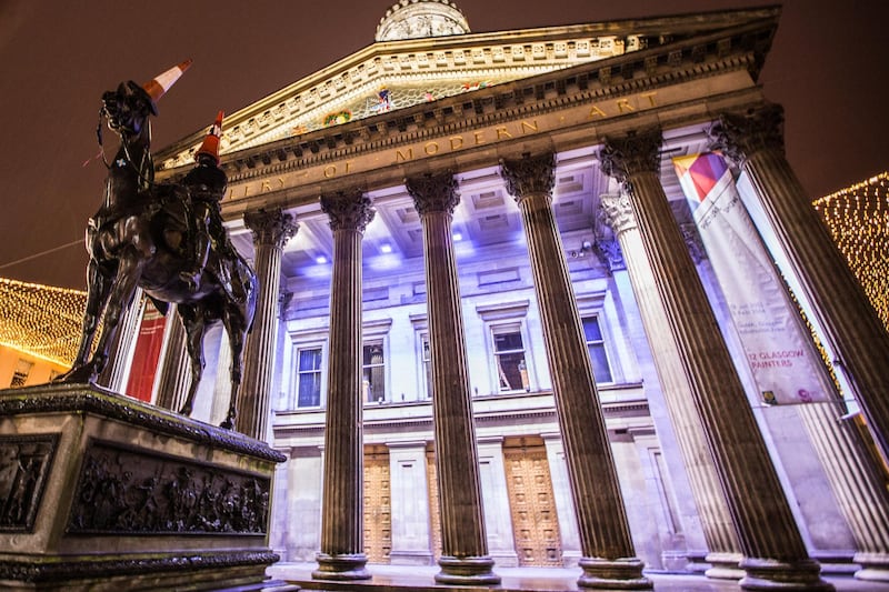 The Gallery of Modern Art (GoMA) in Glasgow at night, the statue of the Duke of Wellington with a traffic cone.