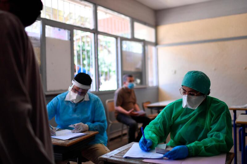 Health workers record taxi drivers' information prior to collecting swab samples from them in Rabat, Morocco. EPA