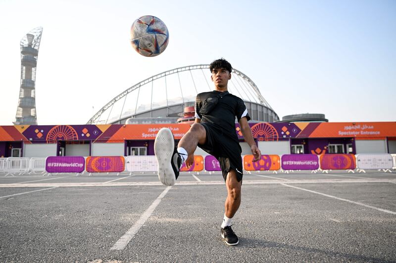 A boy practice his football skills in front of the Khalifa Stadium in Doha ahead of the Qatar 2022 FIFA World Cup football tournament. AFP