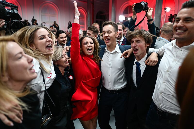 Supporters of Poland's centrist opposition celebrate after an exit poll showed it was on course to topple the government after a record turnout. Getty Images