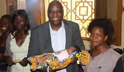 Dr Kouyate stands with two women and a baby in Burkina Faso Dr Kouyate/The National