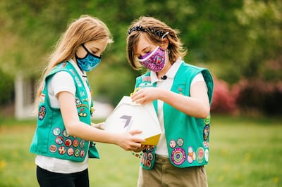 In this April 14, 2021 image provided by Wing LLC., from left, Girl Scouts, Alice and Gracie pose with a Wing delivery drone container in Christiansburg, Va. The company is testing drone delivery of Girl Scout cookies in the area. (Sam Dean/ Wing LLC. via AP)