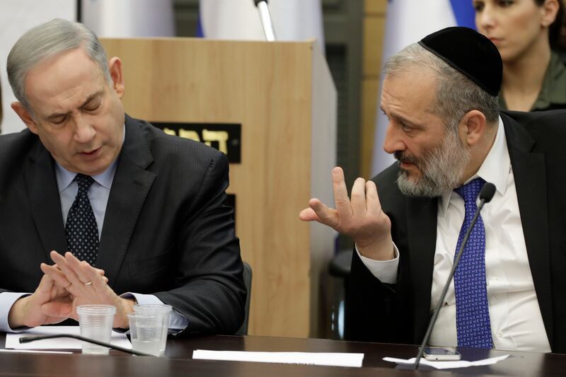 Israeli Prime Minister Benjamin Netanyahu listens to Aryeh Deri during a meeting with his nationalist allies and Likud party members at the Knesset in March 2020.  AP