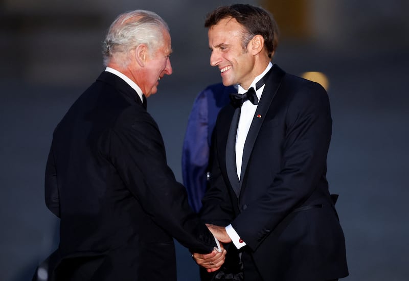 Mr Macron greets King Charles before the dinner in the monarch's honour. Reuters