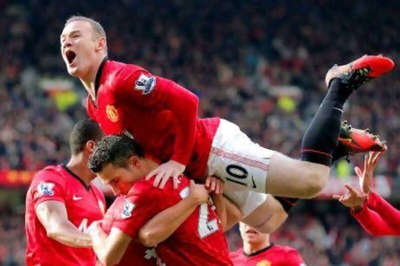 Robin van Persie, centre bottom, is mobbed by his Manchester United teammates after opening the scoring yesterday. Kerim Okten / EPA
