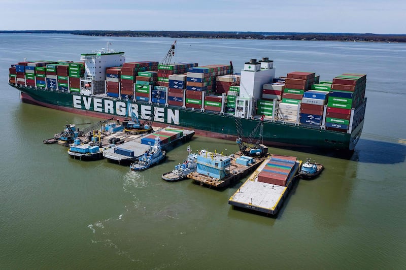 A tugboat pushes a barge full of containers away from the Ever Forward container ship in Pasadena, Maryland, on April 11, 2022, as the cargo ship sits in the Chesapeake Bay after it ran aground near Baltimore.  - Container removal began April 9, 2022, as part of the Ever Forward boxship refloat operation in Chesapeake Bay.  The process, using barges alongside, will continue in daylight hours throughout this week with four to five containers being offloaded per hour in the complex operation.  (Photo by Jim WATSON  /  AFP)