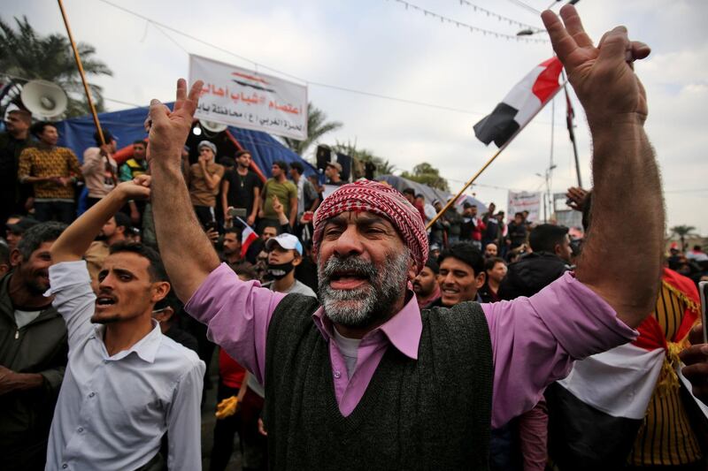 Iraqi demonstrators shout slogans as thee take part in an anti-government demonstration in the capital Baghdad's Tahrir Square, on December 6, 2019.  Tahrir has become a melting pot of Iraqi society, occupied day and night by thousands of demonstrators angry with the political system in place since the aftermath of the US-led invasion of 2003 and Iran's role in propping it up. / AFP / AHMAD AL-RUBAYE
