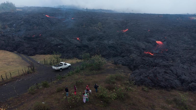People look at lava gushing down the slopes of Pacaya Volcano near El Patrocinio village in San Vicente Pacaya, Guatemala. AP Photo