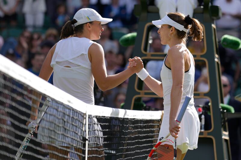 Cornet, right, shakes hands with Swiatek after the match. AP