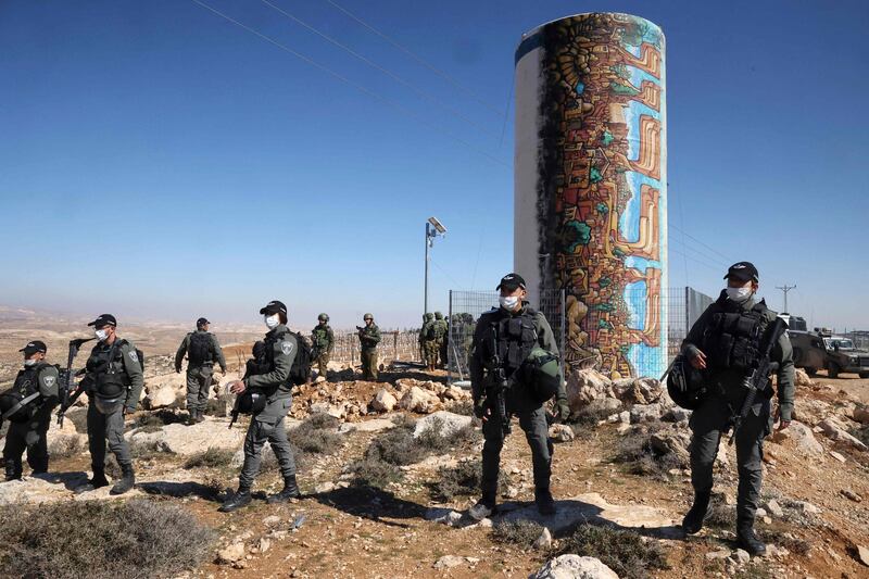 Israeli security officers deploy as Palestinian landowners demonstrate next to land confiscated for the Israeli settlement of Karmel (background), near Yatta village south of Hebron city in the occupied West Bank. AFP