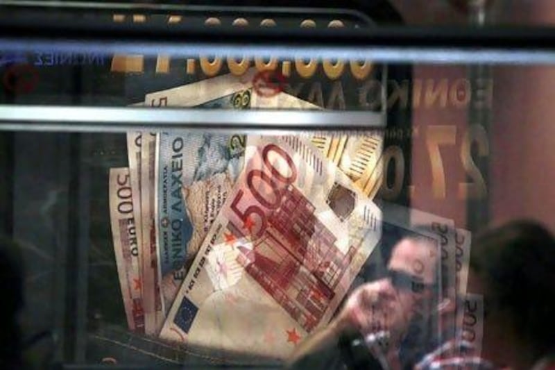 An advertisement featuring Greek euro currency notes are seen through a metro train window in Athens, Greece. Kostas Tsironis/Bloomberg