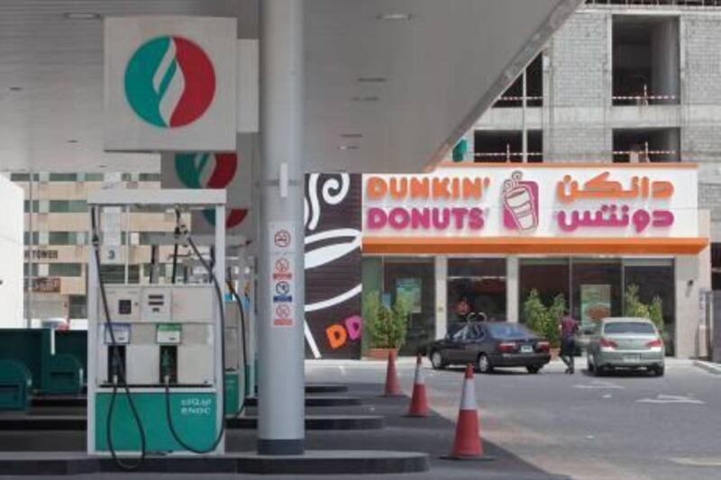 Sharjah - June 29, 2011 - A man walks to a Dunkin' Donuts that remains open while this ENOC station is closed in Sharjah, June 29, 2011. (Photo by Jeff Topping/The National) 

 