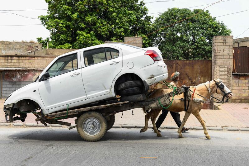 Pulling power ... a man with his horse and cart take a car to a repair shop along a street in Amritsar, India. AFP