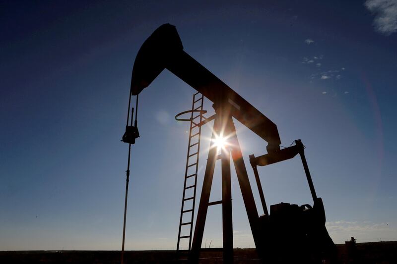 FILE PHOTO: The sun is seen behind a crude oil pump jack in the Permian Basin in Loving County, Texas, U.S., November 22, 2019. REUTERS/Angus Mordant/File Photo