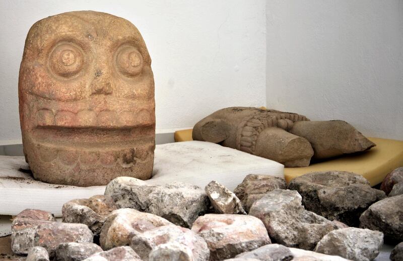 In this 2018 photo provided by Mexico's National Institute of Anthropology and History, INAH, a skull-like stone carving and a stone trunk depicting the Flayed Lord, a pre-Hispanic fertility god depicted as a skinned human corpse, are stored after being excavated from the Ndachjianâ€“Tehuacan archaeological site in Tehuacan, Puebla state, where archaeologists have discovered the first temple dedicated to the deity. Although depictions of the god, Xipe Totec, had been found before in other cultures, a whole temple had never been discovered. (Meliton Tapia Davila/INAH via AP)