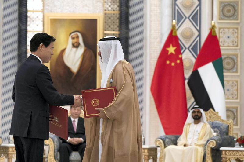 ABU DHABI, UNITED ARAB EMIRATES - July 20, 2018:  HE Sultan bin Saeed Al Mansouri, UAE Minister of Economy (R), exchanges an MOU with a member of the Chinese delegation, at the Presidential Palace. Witnessed by HH Sheikh Mohamed bin Rashid Al Maktoum, Vice-President, Prime Minister of the UAE, Ruler of Dubai and Minister of Defence (back R) and HE Xi Jinping, President of China (back L),

( Mohamed Al Hammadi / Crown Prince Court - Abu Dhabi )
---