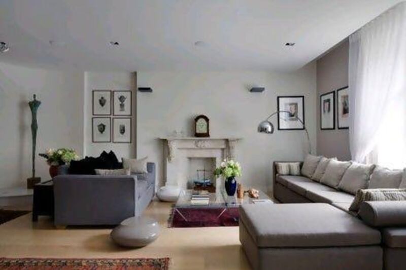 The straight, sleek lines of the living room sofas, along with an ultra-modern coffee table and floor lamp, lend a contemporary feel to antique rugs and a mantel clock from 1780. Bruce Hemming / Gap Interiors