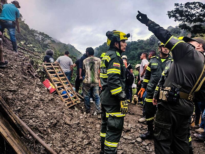 Handout picture released by Colombia's National Police press office showing rescuers woring in the site of a landslide in the sector El Ruso, Pueblo Rico municipality, in northwestern Bogota, Colombia, on December 4, 2022.  - Brigaders are trying to rescue 31 people who were buried under a landslide while travelling in a bus and a motorbike in an accident that also left five people injured and a minor dead, officials said.  (Photo by Handout  /  COLOMBIA'S NATIONAL POLICE PRESS OFFICE  /  AFP)  /  RESTRICTED TO EDITORIAL USE - MANDATORY CREDIT "AFP PHOTO - COLOMBIA'S NATIONAL POLICE PRESS OFFICE " - NO MARKETING - NO ADVERTISING CAMPAIGNS - DISTRIBUTED AS A SERVICE TO CLIENTS