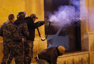 A riot police officer fires rubber bullets towards anti-government protesters trying to enter parliament square in downtown Beirut, Lebanon, Saturday, Dec. 14, 2019. The recent clashes marked some of the worst in the capital since demonstrations began two months ago. The rise in tensions comes as politicians have failed to agree on forming a new government. (AP Photo/Hussein Malla)