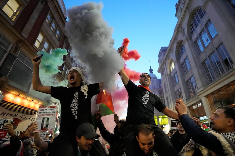 Palestinian supporters light flares at a demonstration in London. AP