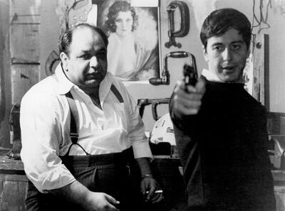 Richard S Castellano watching Al Pacino aim gun in a scene from the film 'The Godfather', 1972. (Photo by Paramount/Getty Images)