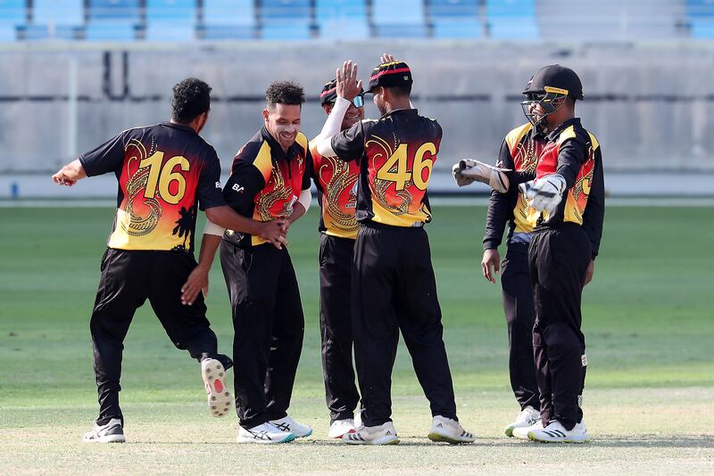 PNG's Chad Soper, second left, celebrates after taking the wicket of UAE batter Alishan Sharafu for 14.
