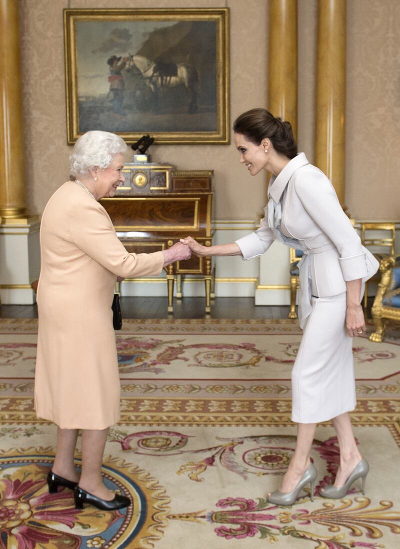 Jolie being presented with the Insignia of an Honorary Dame Commander of the Most Distinguished Order of St Michael and St George by Queen Elizabeth II at Buckingham Palace. PA