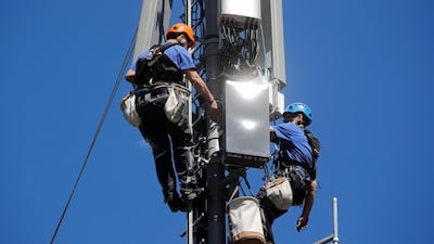 Technicians are roped up as they install 5G antennas. The new network is expected to carry 35 per cent of mobile data traffic globally by 2024, according to Ericsson. Reuters