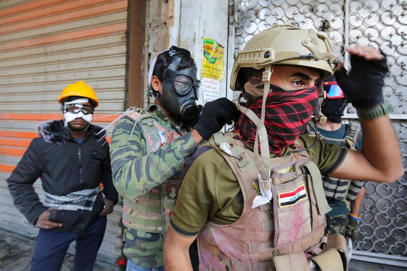 Iraqi protesters cover their faces during a demonstration in Baghdad's al-Rasheed street near al-Ahrar bridge. AFP