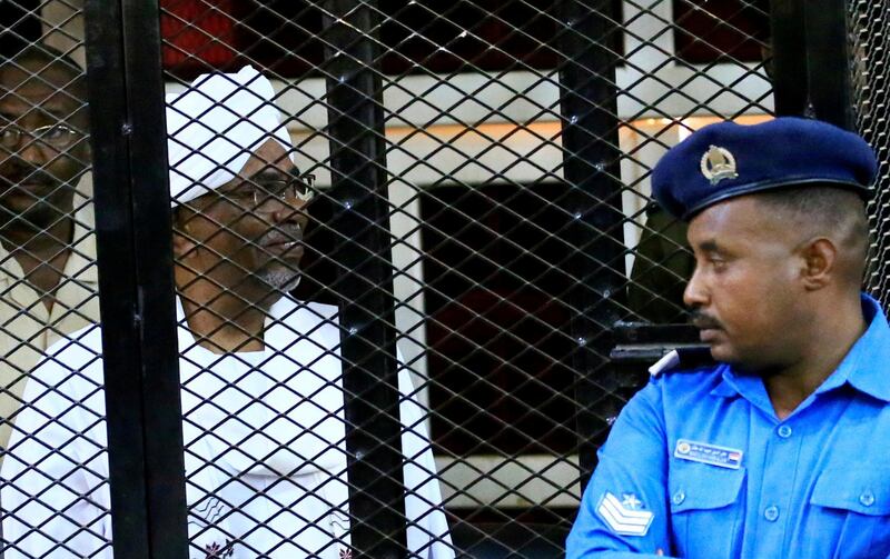 FILE PHOTO: Sudan's jailed former president Omar Hassan al-Bashir sits inside a cage during a court hearing in Khartoum, Sudan, December 14, 2019. REUTERS/Mohamed Nureldin Abdallah/File Photo