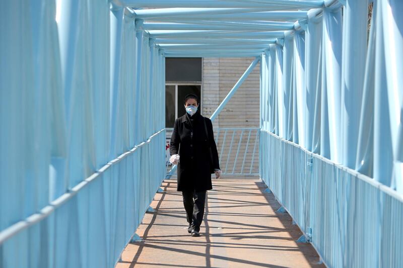 An Iranian pedestrian walks while wearing a protective mask in Tehran on March 10, 2020 amid the spread of coronavirus in the country. Iran today reported 54 new deaths from the novel coronavirus in the past 24 hours, the highest single-day toll since the start of the country's outbreak.
 / AFP / ATTA KENARE
