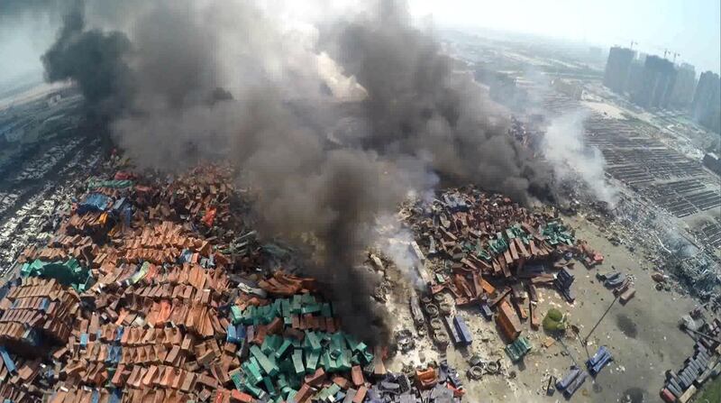 This screen grab taken from AFPTV shows an aerial image taken on August 13, 2015 of smoke rising from debris the day after a series of explosions hit a chemical warehouse in the city of Tianjin, in northern China.  A Chinese military team of nuclear and chemical experts began work on August 14 at the site of two massive explosions in the city of Tianjin, state media said, as pressure grows for authorities to explain the cause of blasts that left 50 dead. CHINA OUT     AFP PHOTO / AFPTV (Photo by AFPTV / AFPTV / AFP)