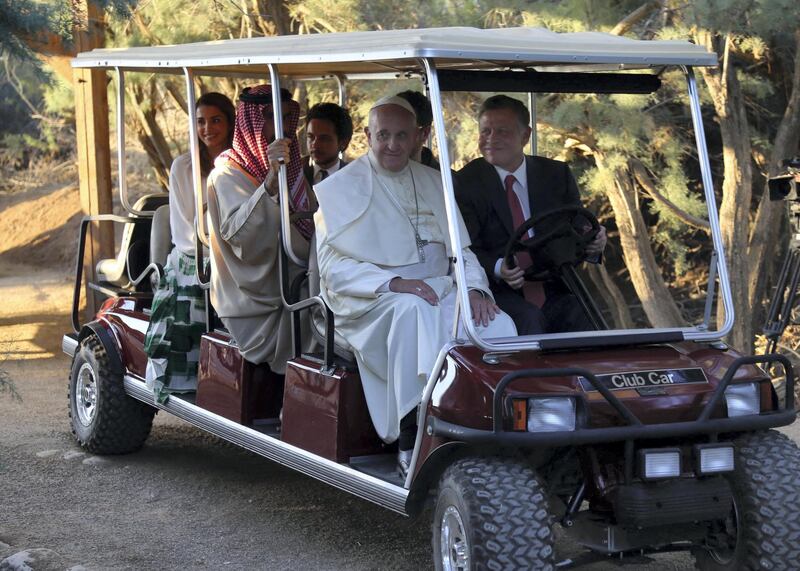 Pope Francis (Front-L) sits in a golf cart next to King Abdullah II of Jordan (Front-R) as they visit Bethany, a site on the eastern bank of the River Jordan where some Christians believe Jesus was baptised, on May 24, 2014. Pope Francis called for fresh peace talks on Syria, urging all sides to swap arms for negotiations to bring an end to the three-year civil war there. AFP PHOTO / SAMI KHAHMAN (Photo by SAMI KHAHMAN / AFP)
