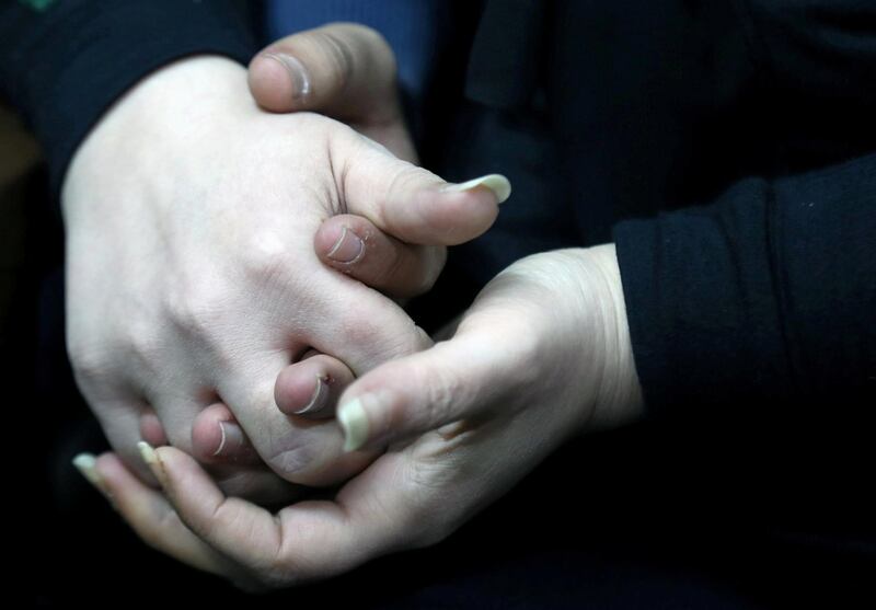 Amjad Yaghi and his mother hold hands. Reuters