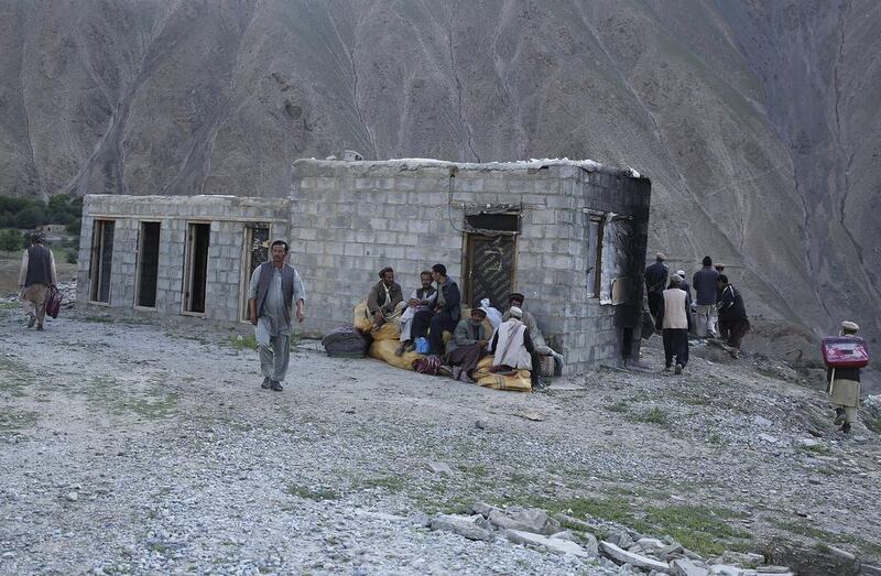 Flood-affected residents of Gozargah-e-Noor district in Baghlan province receive donations from Afghan chief executive Abdullah Abdullah in June 8, 2014, when he was campaigning for the presidency. Massoud Hossaini / Reuters