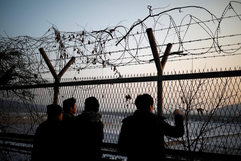 People look towards the north through a barbed-wire fence near the militarized zone separating the two Koreas, in Paju, South Korea. Kim Hong-Ji / Reuters