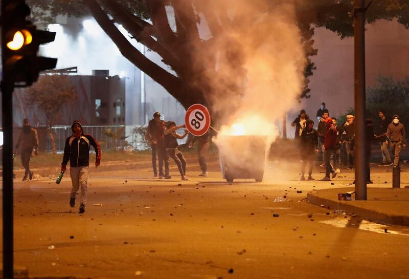 Anti-government protesters burn a rubbish container and throw bottles at riot police during a protest in central Beirut. AP Photo