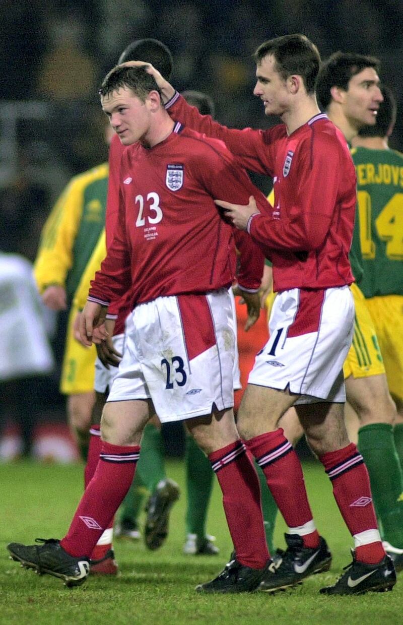 Wayne Rooney (L-23), the youngest player ever for England, receives consolation from colleague Francis Jeffers at the end of match after Australia beat England 3-1 in a friendly at West Ham's ground in East London 12 february 2003. / AFP PHOTO / MARTIN HAYHOW