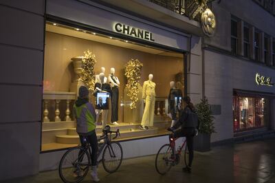 Cyclists stop to look in the window of a Chanel SA store on Bond Street in London, U.K., on Wednesday, Dec. 23, 2020. Shops in Britain had only recently reopened from lockdown when the government ordered non-essential stores in southeast England to shut again on Sunday in a bid to stem a more infectious mutation of Covid-19. Photographer: Jason Alden/Bloomberg