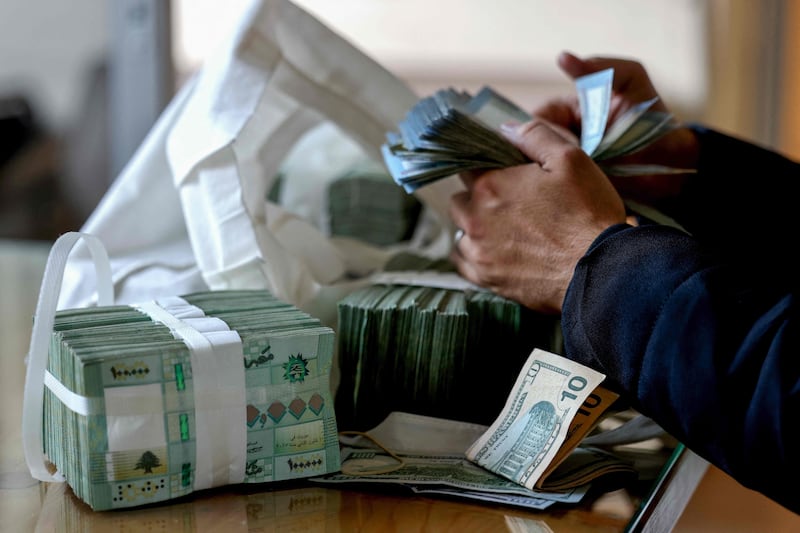 A clerk counts Lebanese banknotes at a currency exchange in Beirut. AFP