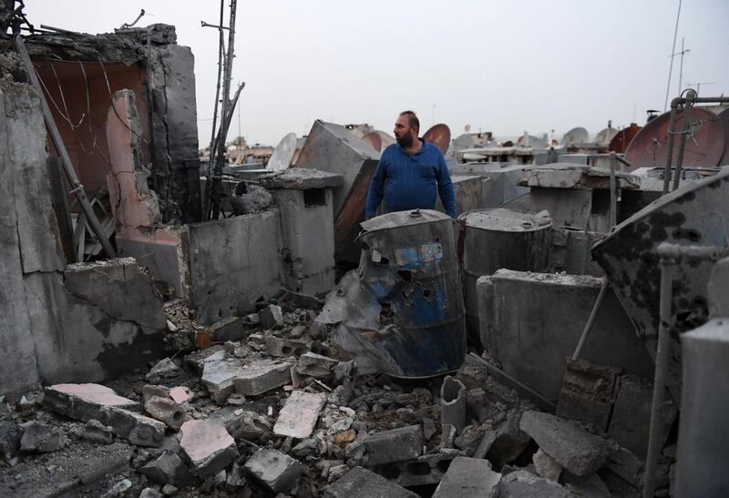 A resident stares at the damage on the roof of a building that was hit by a rocket in the northern Syrian city of Aleppo. AFP